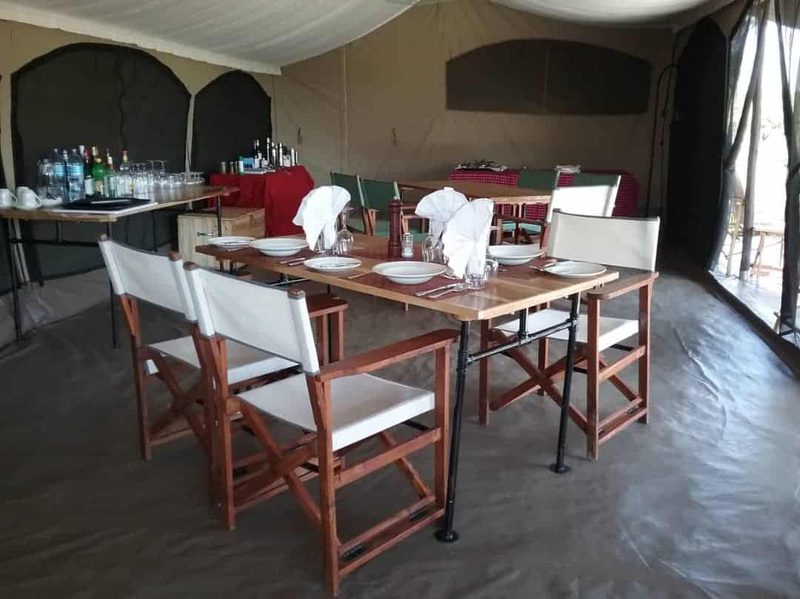Dining tables laid with folded white napkins in the mess tent