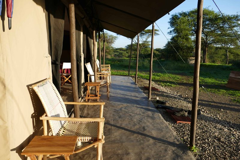 Mess tent veranda with cane chairs and a director's chair