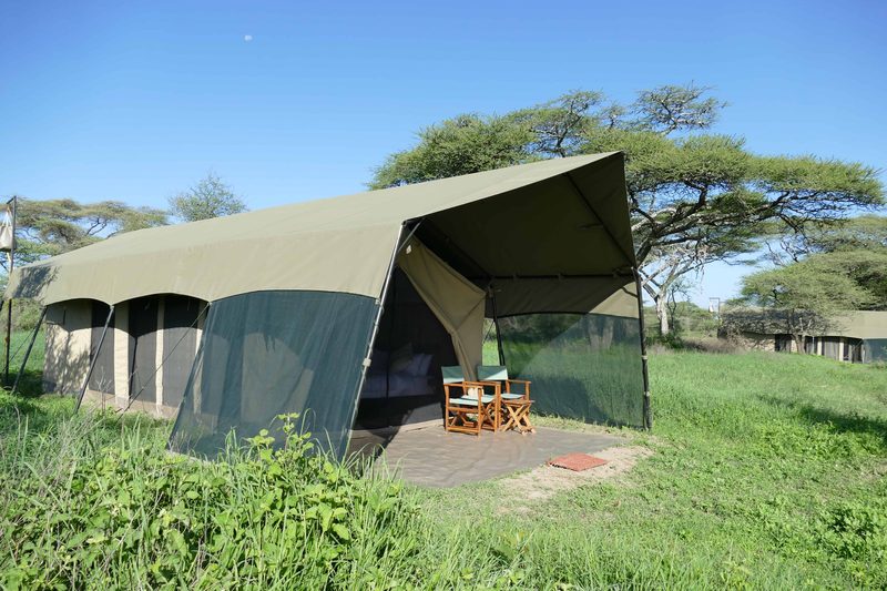 Guest tent with a mesh veranda and two chairs, set on green grass