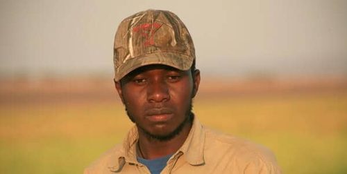 Sosy Maria in a camouflage cap against a golden evening background